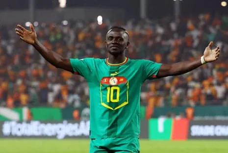 Sadio Mané Celebrates Sadio Mané, the Senegal forward wearing No 10, celebrates scoring a goal for his country at the Africa Cup of Nations by standing before the fans with his arms spread wide.