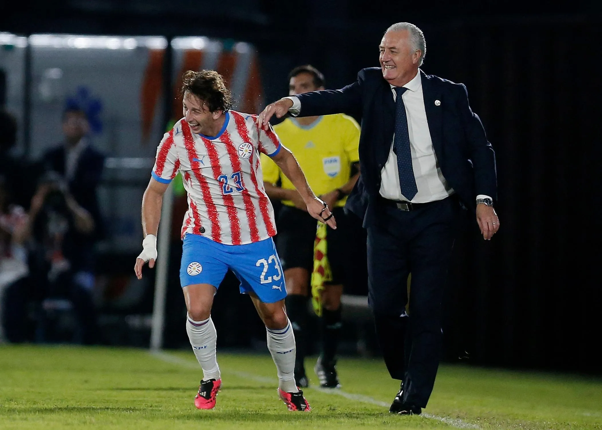 Matías Galarza celebrates with coach Gustavo Alfaro after scoring Paraguay’s third goal against Nicaragua.