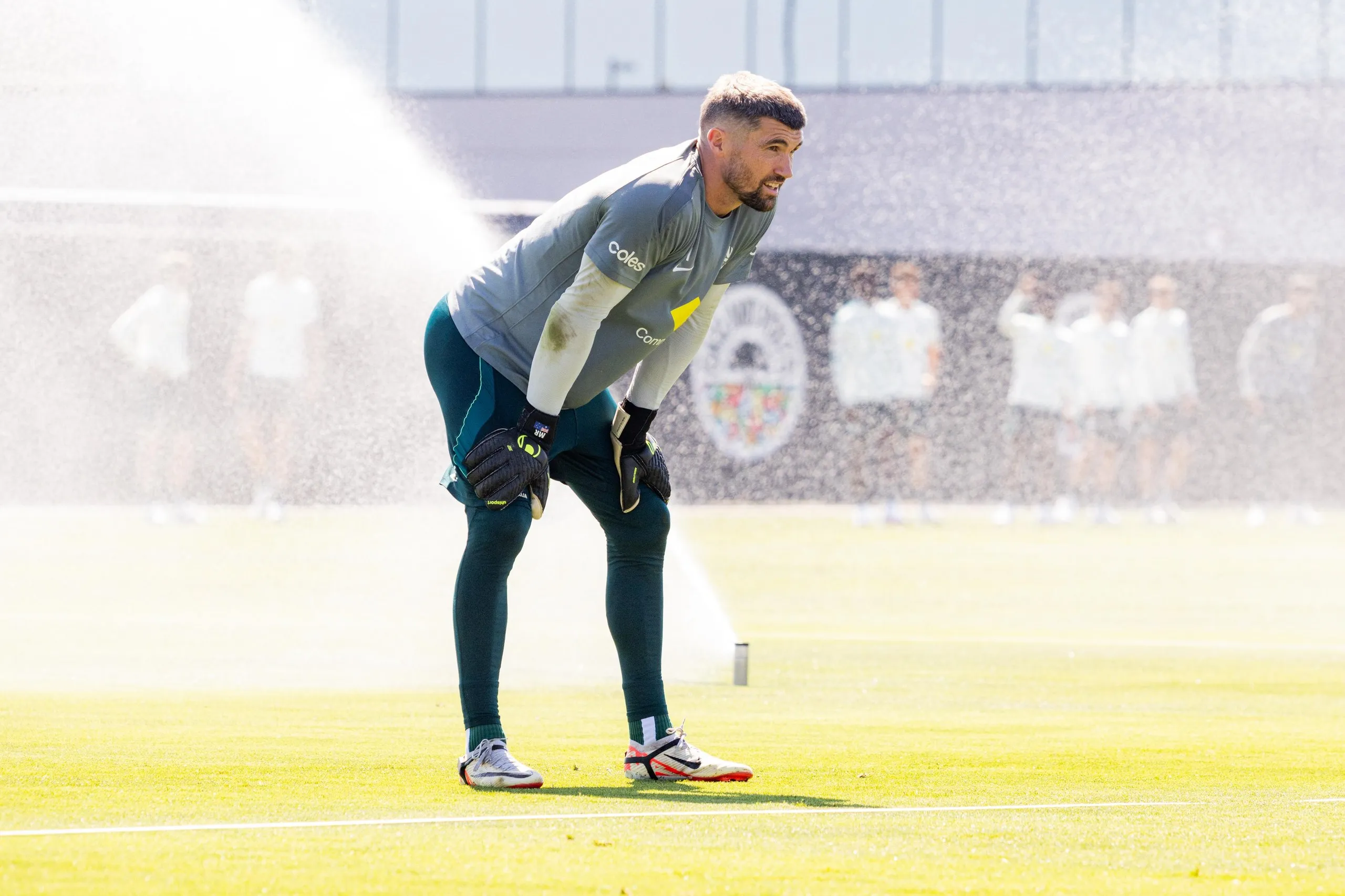 Mathew Ryan trains in front of a sprinkler