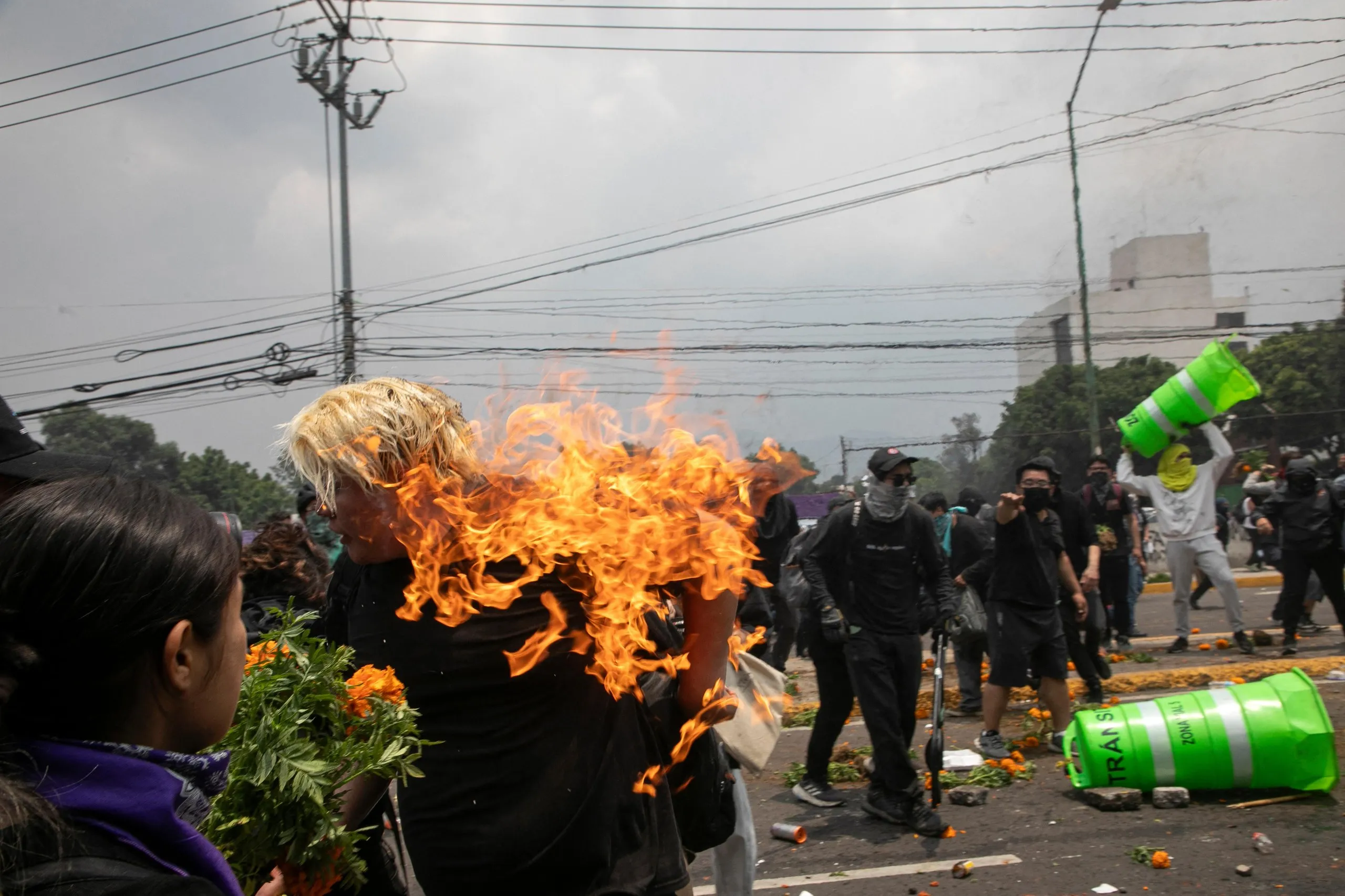 A person catches fire during clashes between protesters and the police before the opening ceremony.