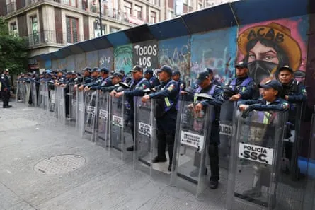 Police presence at Zocalo fan zone Police officers stand guard near the Zocalo fan zone, where dissident teachers have set up an encampment to demand higher wages and pensions
