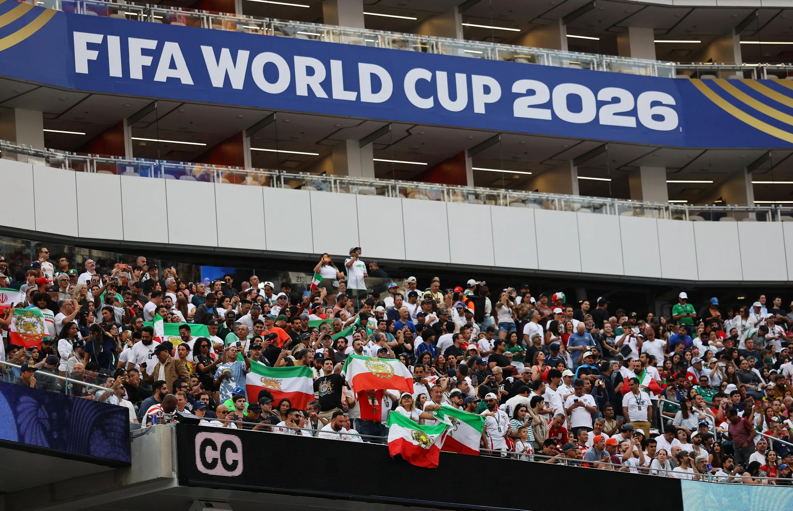 Iran fans display pre-Iranian Revolution "Lion and Sun" flags inside the stadium before the match.