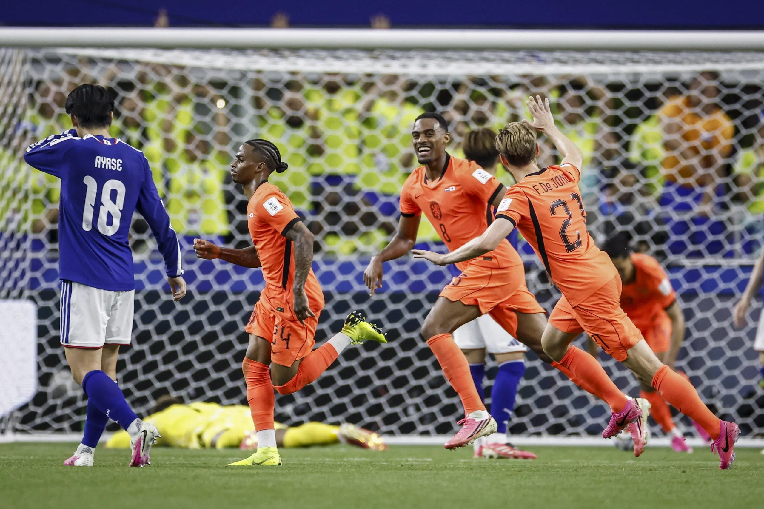 Crysencio Summerville celebrates with teammates as Japan’s goalkeeper lies flat on his face