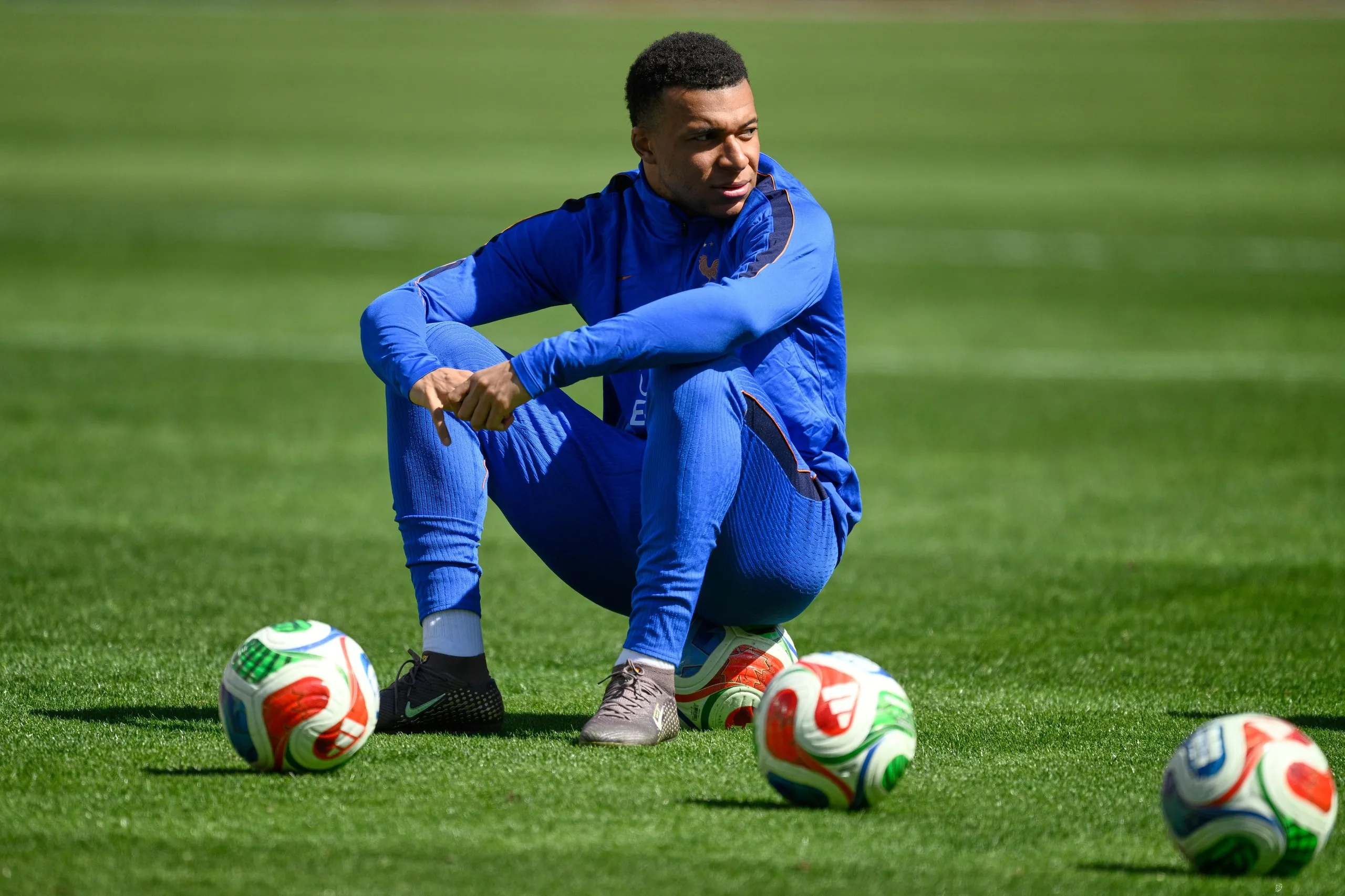 Kylian Mbappé sitting on a football