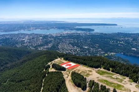 Giant Canadian Flag on Grouse Mountain A giant Canadian flag on Grouse Mountain above the city of Vancouver, where the cost of the tournament has skyrockted