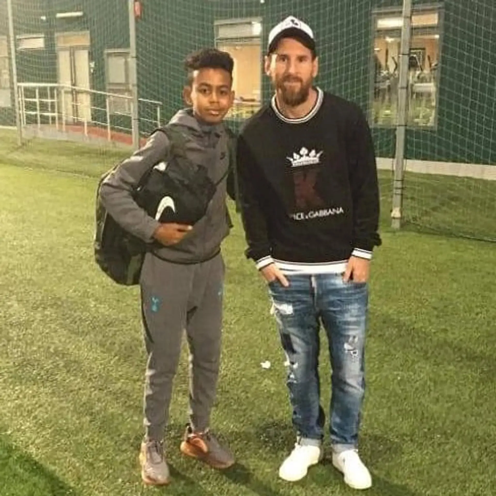 A young Lamine Yamal stands with Lionel Messi