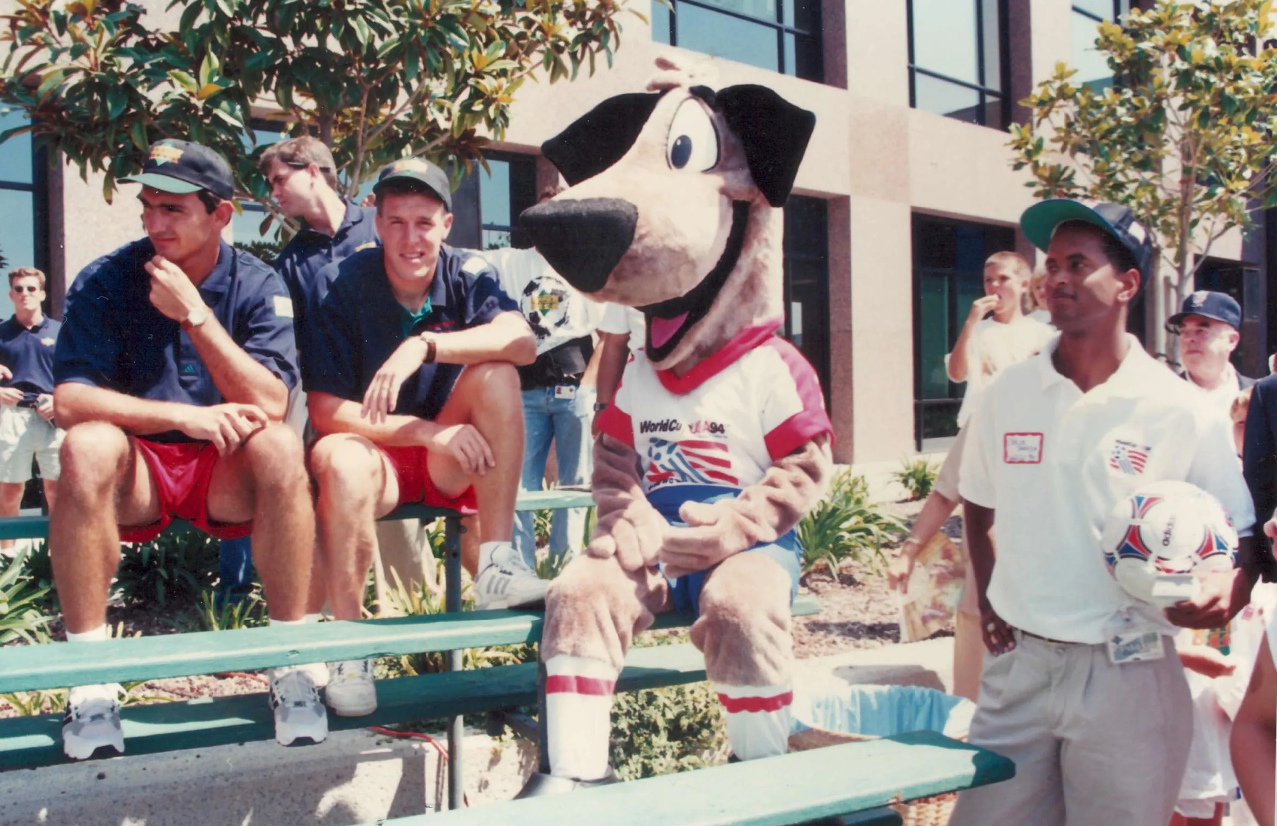 Striker on a set of bleachers with two members of the US national team.