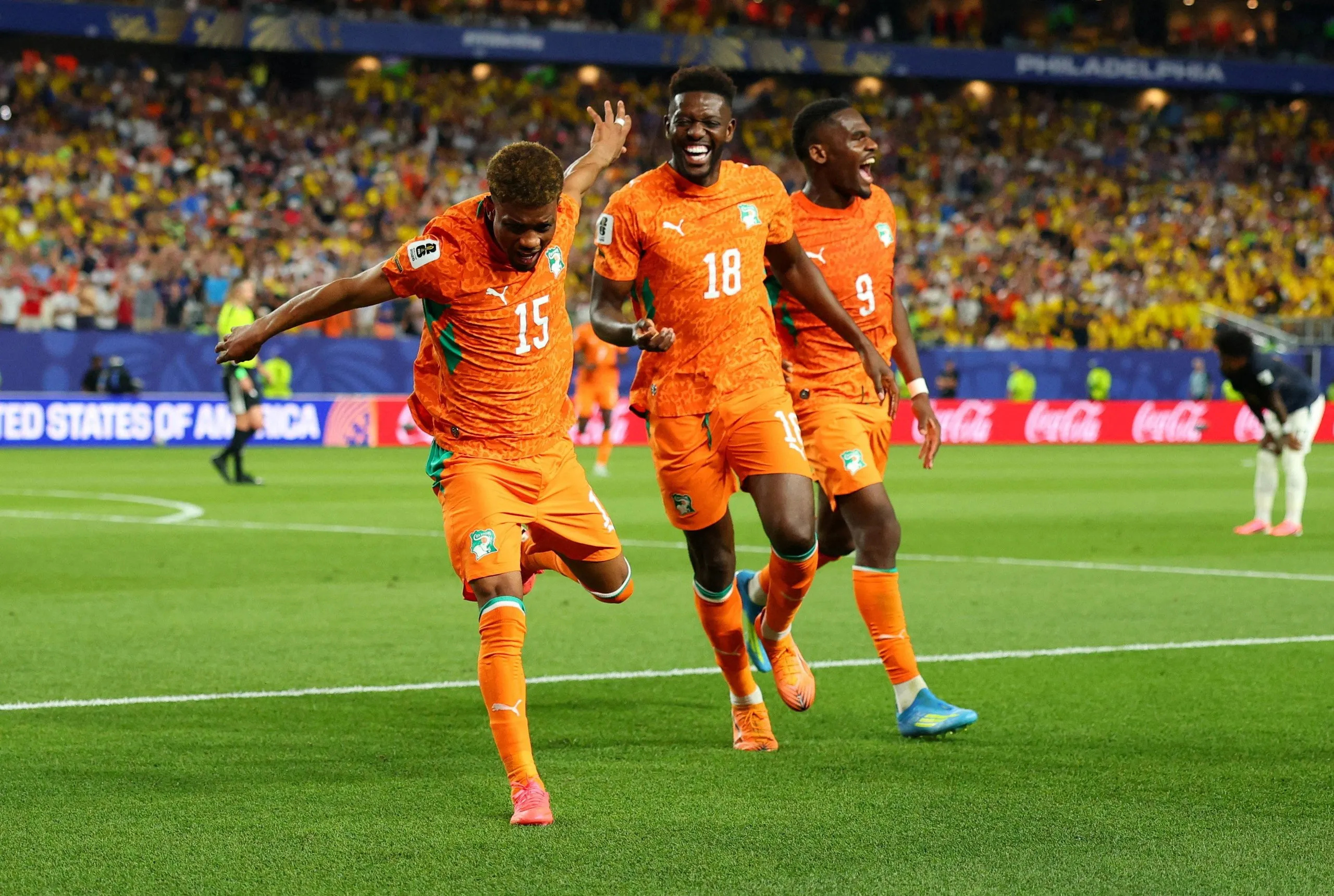Amad Diallo wearing an orange Côte d’Ivoire jersey celebrates after scoring a goal.