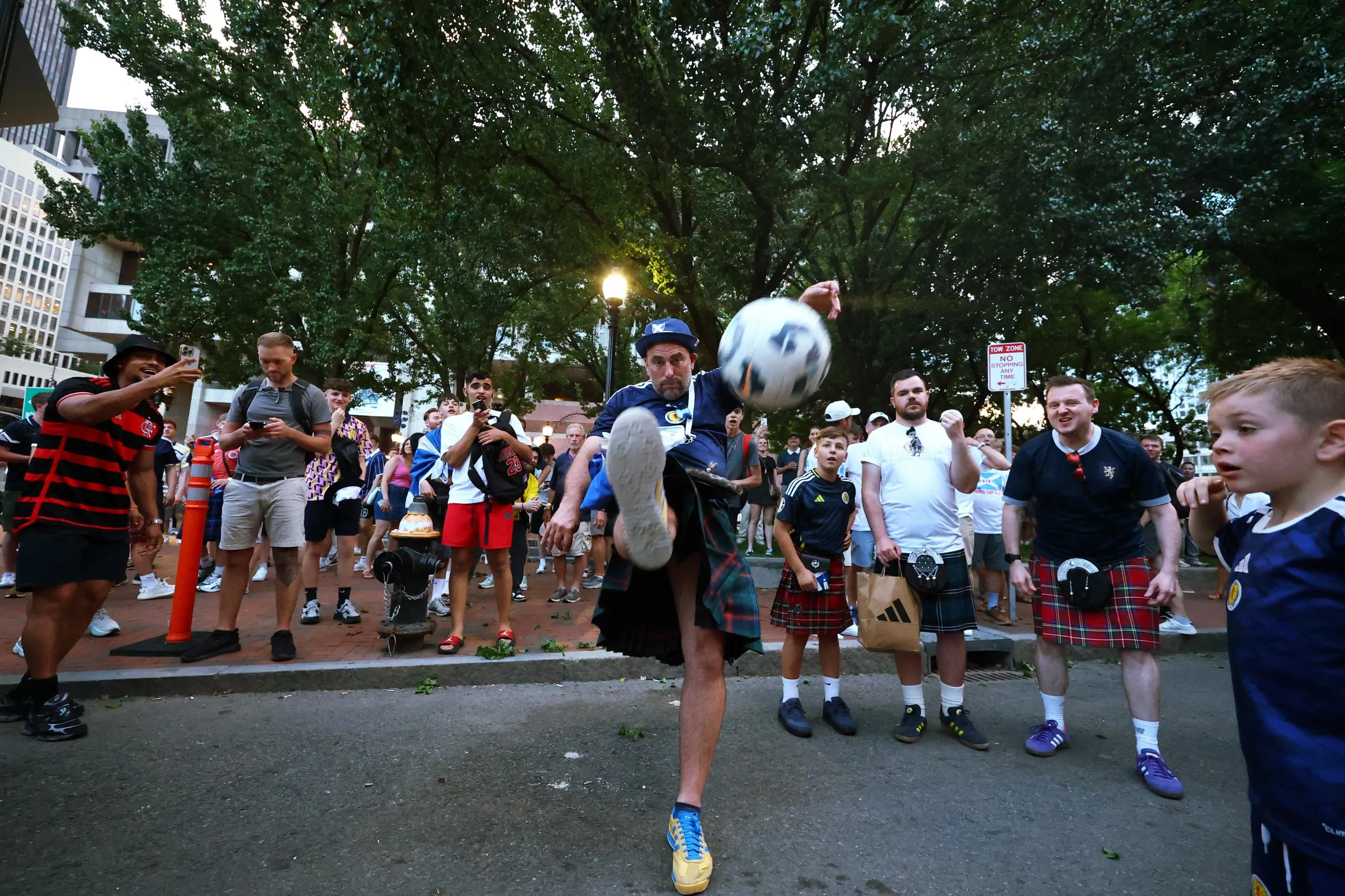A Scotland fan wearing a kilt plays football in a street in Boston before the match against Haiti.