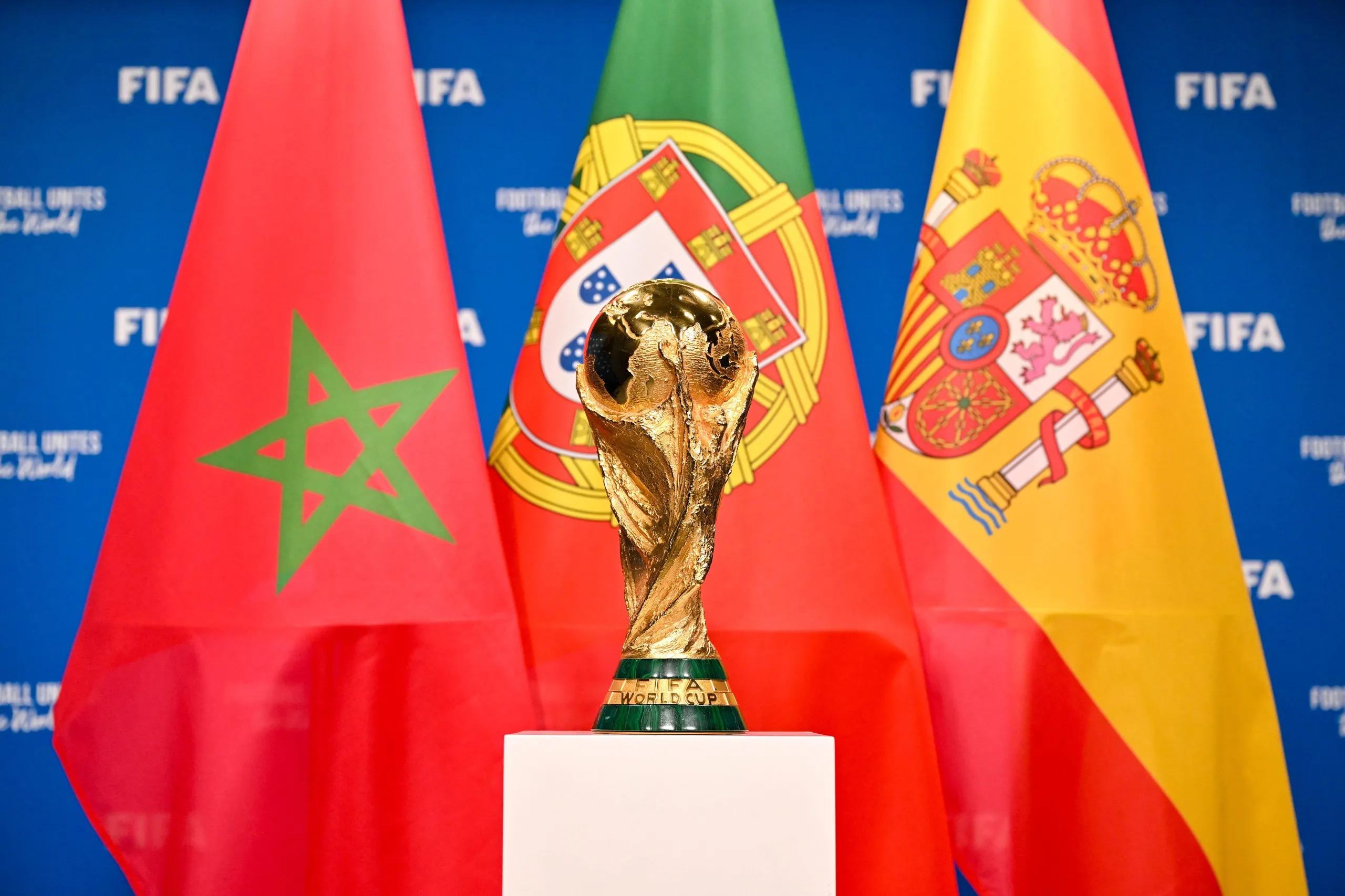 The World Cup stands in front of the flags of Morocco, Portugal and Spain.